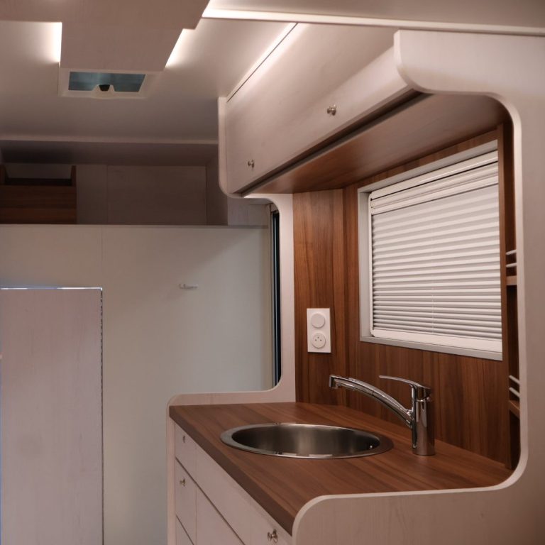 Intérieur d'une cuisine moderne avec un évier et des finitions en bois clair.